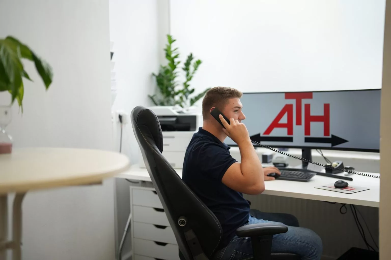 ATH-Mitarbeiter während eines Telefongesprächs im Büro.