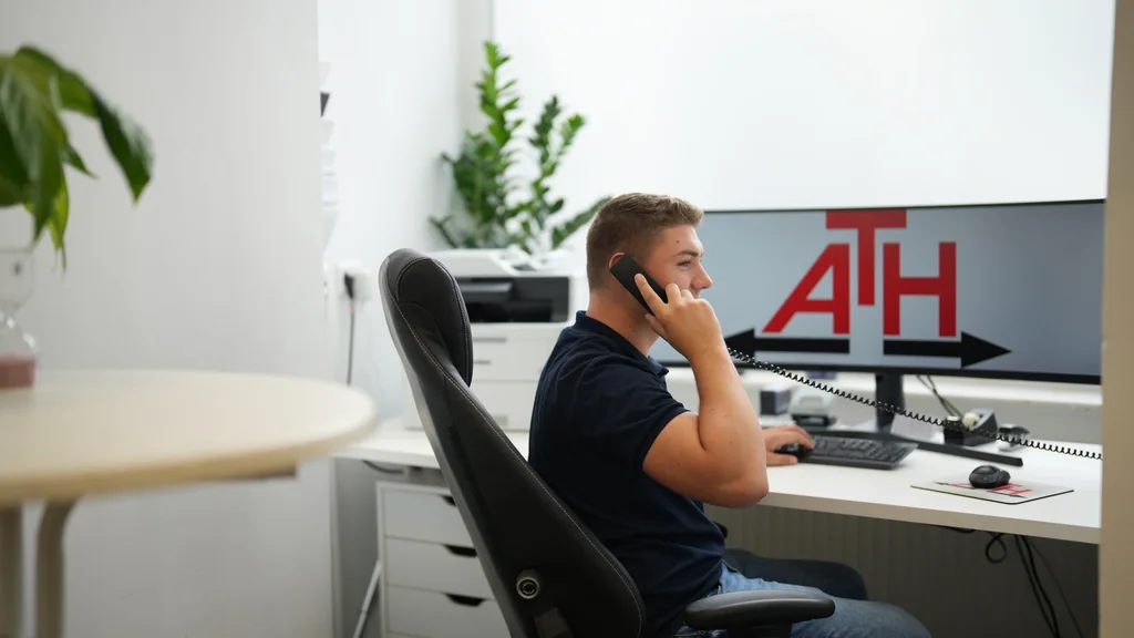 ATH-Mitarbeiter im Büro während eines telefonischen Beratungsgesprächs.