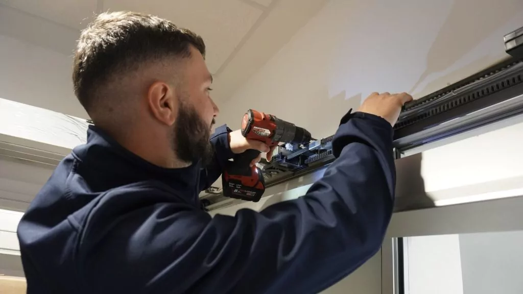 ATH-Techniker montiert Komponenten am Antrieb einer automatischen Tür.